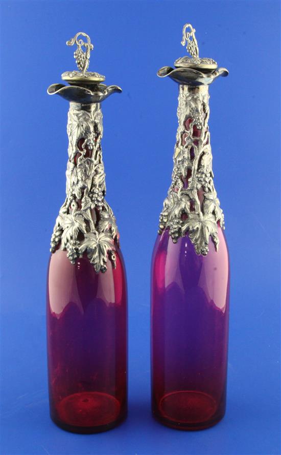 A pair of early 20th century plate mounted double lipped ruby glass bottle decanters & stoppers, 14.25in.